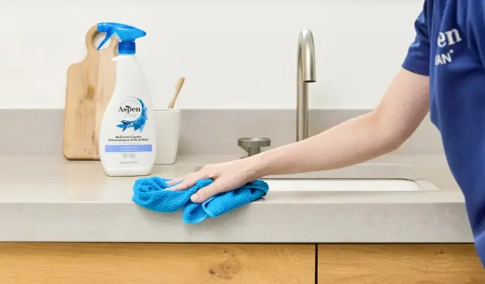AspenClean products and a team member cleaning a countertop